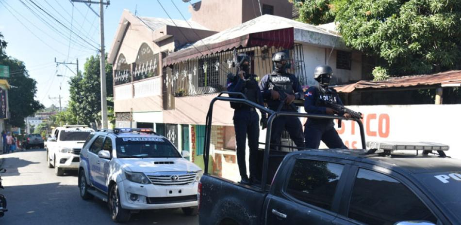 Personal de equipos especiales de la Policía, a bordo de varias unidades, recorren calles de Los Alcarrizos, vigilan atentos para garantizar la paz en la zona. / Archivo