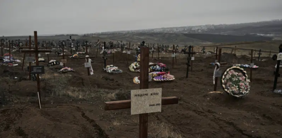 Una cruz sobre una tumba nueva con las palabras "Mujer desconocida" se ve en un cementerio en Bakhmut, escenario de fuertes combates entre tropas ucranianas e invasores rusos, en la región de Donetsk, Ucrania, el domingo 18 de diciembre de 2022. (AP Foto/LIBKOS