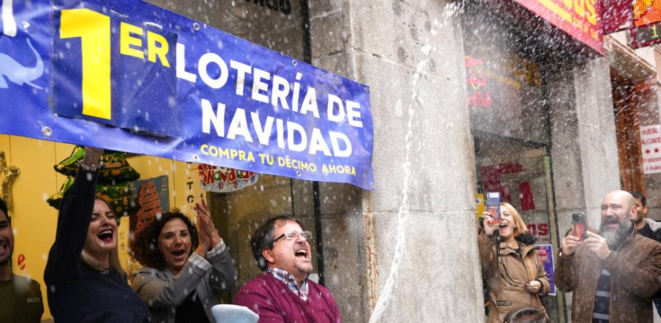 El dueño de una administración de lotería celebra la venta de uno de los boletos de lotería conocido como "El Gordo", vendido en su tienda en Madrid, España, el jueves 22 de diciembre.