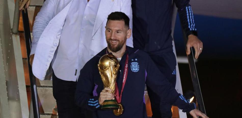 Lionel Messi de la selección argentina de fútbol desciende con el trofeo del Mundial de Fútbol Qatar 2022 a su llegada hoy, al Aeropuerto Internacional de Ezeiza a unos 22km de Buenos Aires (Argentina). EFE/ Raúl Martínez