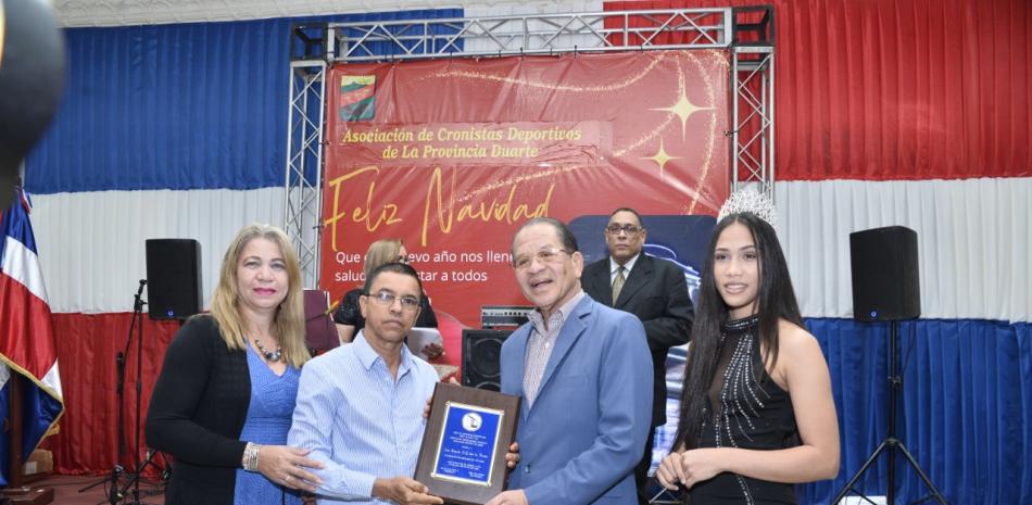 Siquio Ng de la Rosa recibe una placa de reconocimiento de David Díaz y Sonia López en las premiaciones de la asociación de Cronistas Deportivos provincial.