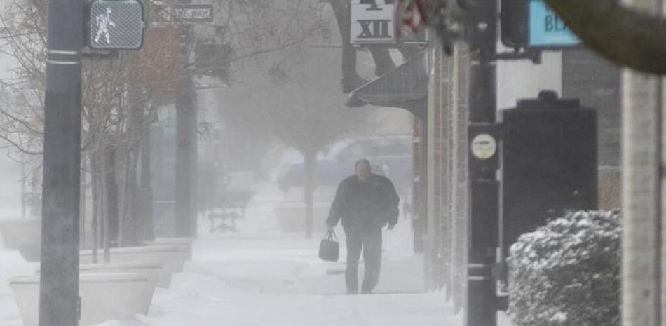 Un peatón camina por el centro de Wichita, Kansas, durante una tormenta de nieve el jueves 22 de diciembre de 2022.