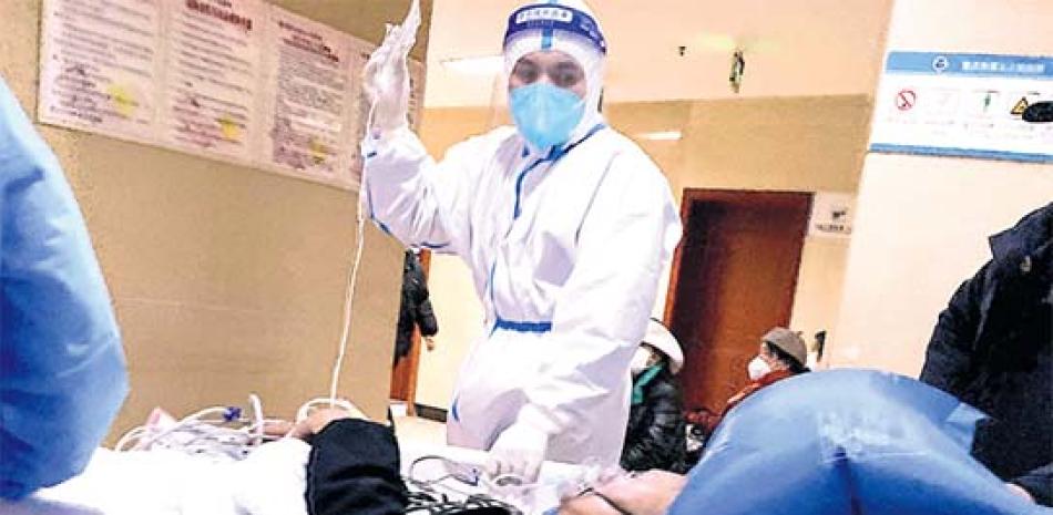Un trabajador de la salud revisa a un paciente con Covid en Chongqing, en el suroeste de China. AFP