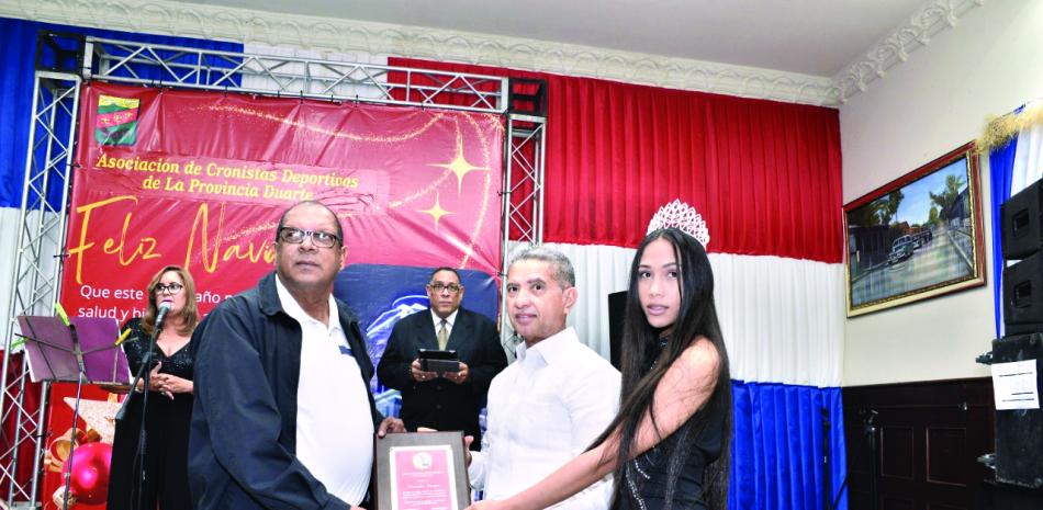 Kennedy Vargas recibe una placa de reconocimiento del ingeniero Tabaré Peña.