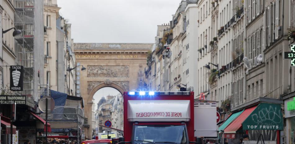 Una ambulancia de los bomberos se ve detrás de la cinta policial donde se produjo un tiroteo en París, el viernes 23 de diciembre de 2022. AP.