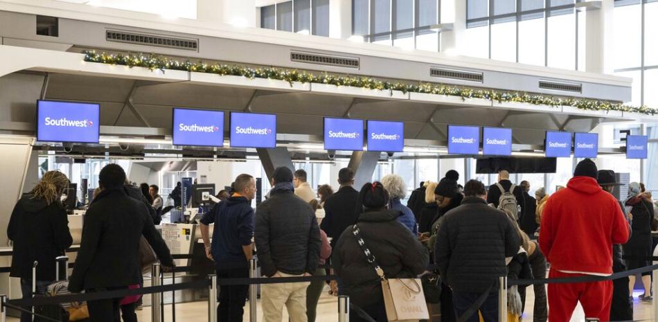 Los pasajeros hacen fila para registrarse para sus vuelos en el mostrador de servicio de Southwest Airlines en el Aeropuerto LaGuardia, el martes 27 de diciembre de 2022, en Nueva York. AP.