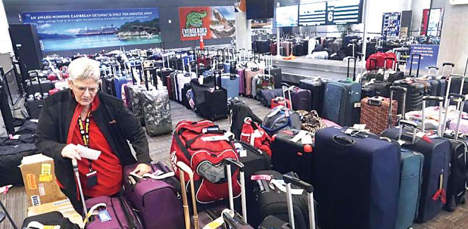 Una empleada de Southwest Airlines revisa equipaje no reclamado y reenviado ayer en el Aeropuerto Internacional Fort Lauderdale, Florida.  AP