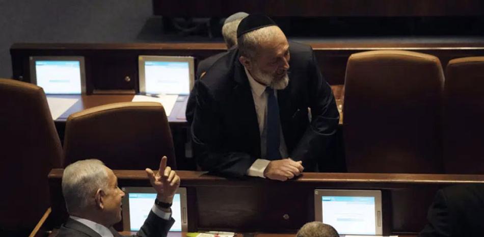 El legislador Aryeh Deri, arriba, habla con el primer ministro Benjamin Netanyahu, a la izquierda, y Yariv Levin, a la derecha, mientras los legisladores se reúnen para votar sobre Levin como presidente de la Knesset, en Jerusalén, el 13 de diciembre. AP