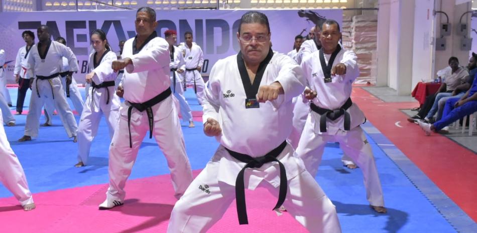 El ministro de Deportes Francisco Camacho en compañía de legendarios deportistas del taekwondo realiza uno de los ejercicios propios de la disciplina.
