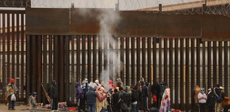 Migrantes que buscan asilo en Estados Unidos se paran alrededor de una fogata para calentarse después de cruzar el Río Grande desde Ciudad Juárez en Chihuahua, México. Foto: AFP
