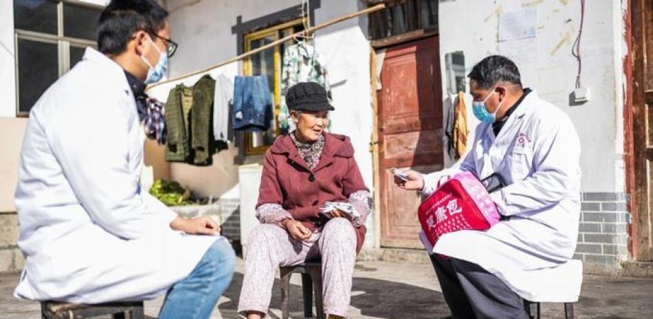 Trabajadores médicos proporcionan medicamentos a una mujer en la aldea de Haifa, en el distrito de Liupanshui, provincia de Guizhou, suroeste de China. EFE