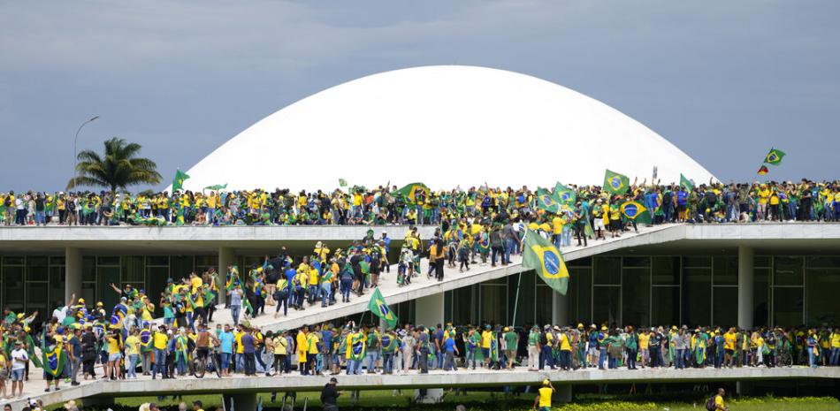 Manifestantes, partidarios del expresidente brasileño Jair Bolsonaro, asaltan el edificio del Congreso Nacional en Brasilia, Brasil, el domingo 8 de enero de 2023. (Foto AP/Eraldo Peres).