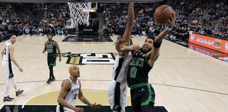 Jayson Tatum, de los Celtics, se eleva en busca de un canasto ante la defensa de Romeo Langford, de los Spurs, en el partido del sábado en el baloncesto de la NBA.