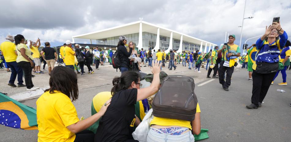 Los manifestantes, partidarios del expresidente de Brasil, Jair Bolsonaro, se arrodillan para orar mientras asaltan el Palacio Planalto en Brasilia, Brasil, el domingo 8 de enero de 2023.