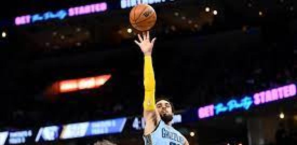 El base de los Grizzlies de Memphis Tyus Jones lanza el balón sobre el pívot de los Spurs de San Antonio Jakob Poeltl en el encuentro del lunes.