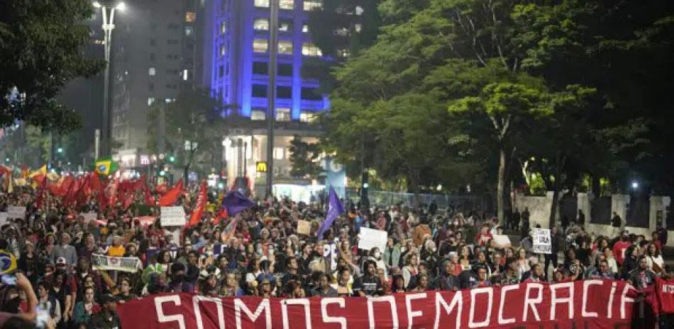Manifestantes marchan con una bandera que dice “Somos democracia” durante una protesta para reclamar la protección de la democracia del país, en Sao Paulo, Brasil, el lunes. AP