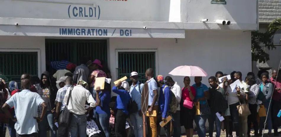 Un grupo de haitianos hacen una fila frente a una oficina de inmigración mientras esperan su turno para solicitar un pasaporte, ayer en Puerto Príncipe. AP