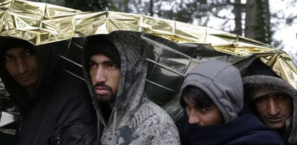 Migrantes esperan por comida en Bosnia. AP