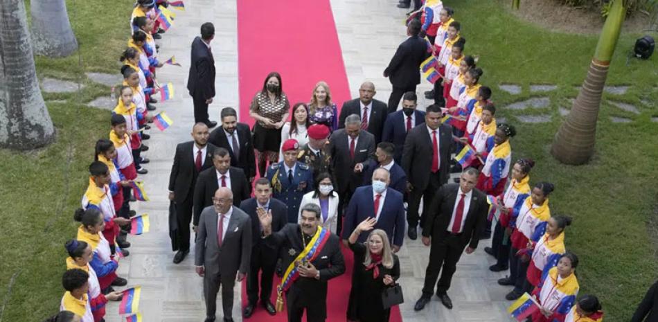 El presidente venezolano Nicolás Maduro, en el centro a la izquierda, y la primera dama Cilia Flores saludan a la población a su llegada a la Asamblea Nacional para dar su rendición de cuentas a la nación anual en Caracas. AP