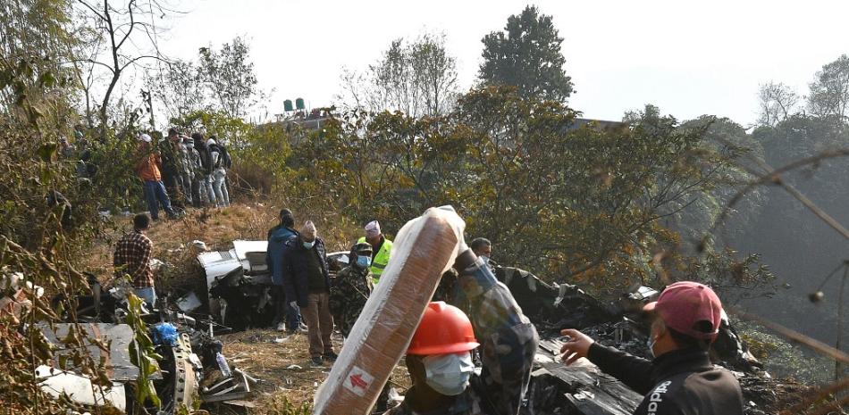 Rescatistas inspeccionan los restos del avión estrellado en Pokhara el 15 de enero de 2023. El 15 de enero se confirmó la muerte de al menos 68 personas al estrellarse en Nepal un avión con 72 personas a bordo, según informó la policía, en la catástrofe aérea más mortífera del país del Himalaya en tres décadas. Foto: Prakash Mathema/AFP.