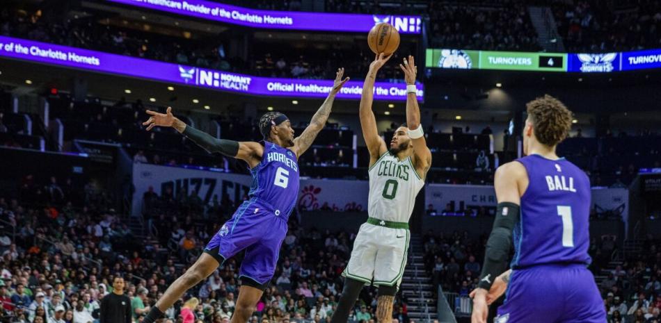 El alero de los Celtics de Boston Jayson Tatum lanza el balón sobre el alero de los Hornets de Charlotte Jalen McDaniels en el encuentro del sábado.