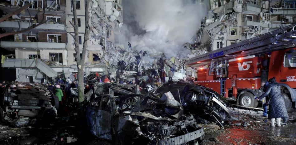 Esta fotografía tomada el 14 de enero de 2023 muestra un coche y un edificio de viviendas destruidos por el impacto de un misil en Dnipro. Fuente: AFP.