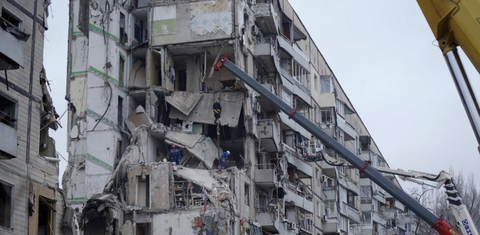 Rescatistas trabajan en un edificio residencial destruido tras el impacto de un misil, en Dnipro, el 16 de enero de 2023, en medio de la invasión rusa de Ucrania. Fuente: AFP.