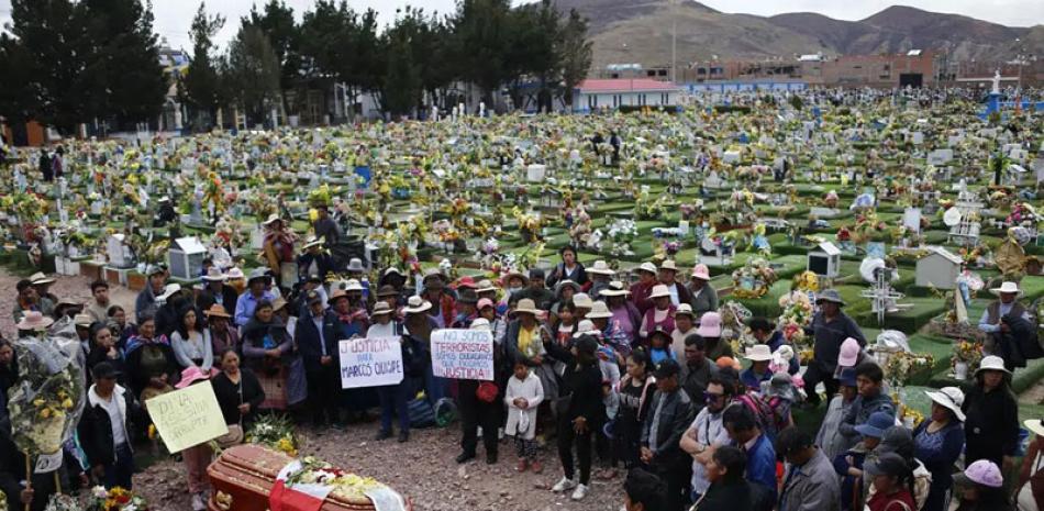 Los dolientes se preparan para enterrar a Marco Quispe, de 54 años, asesinado durante enfrentamientos con la policía, en el cementerio de Juliaca, Perú, el jueves 12 de enero de 2023.  AP