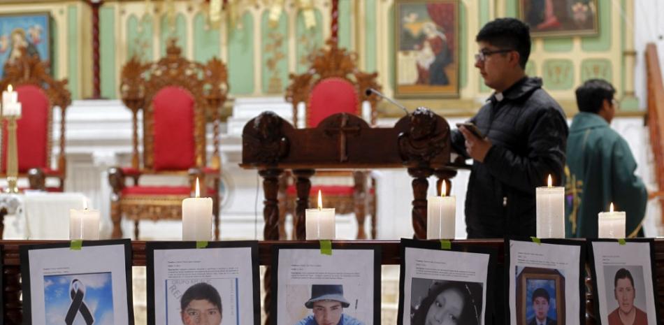 Fotos de las víctimas se muestran en el altar de la iglesia católica de San Juan en memoria de los muertos en las cinco semanas de protestas contra la presidenta Dina Boluarte, el 15 de enero de 2023, en Puno, Perú. Fuente: AFP.