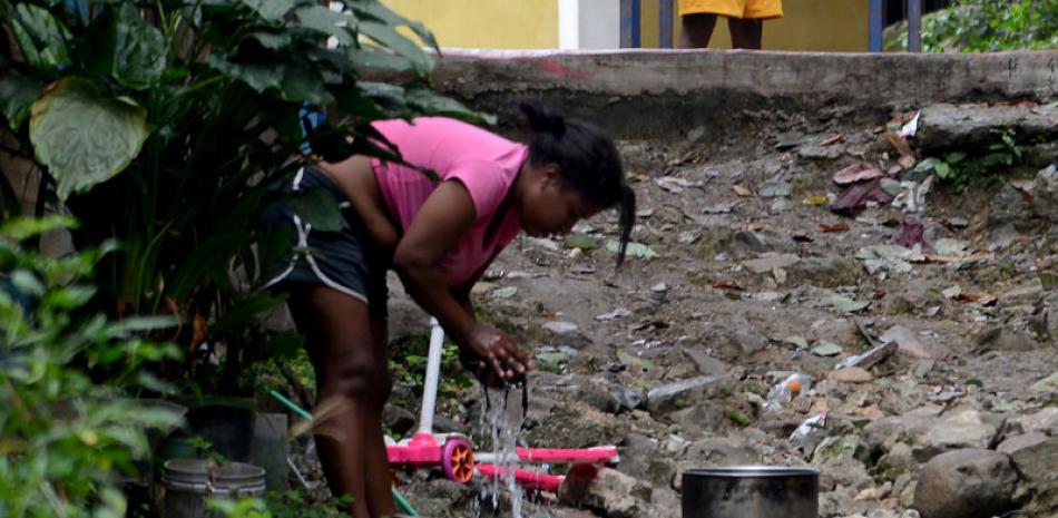 Una mujer se abastece de agua de una tubería instalada en un barrio de la capital.