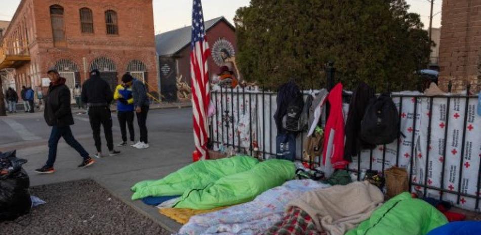Inmigrantes duermen en la acera cerca de un refugio para migrantes el 9 de enero de 2023 en El Paso, Texas. Archivo / AFP