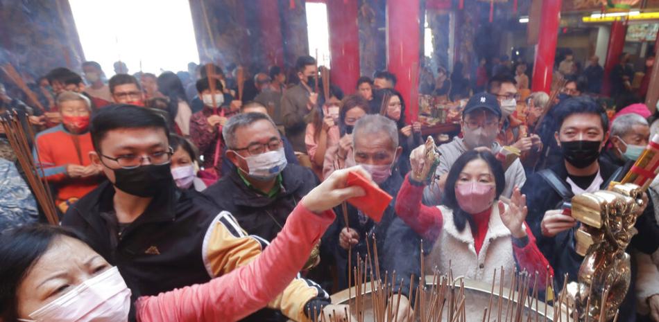 Fieles con mascarillas para ayudar a combatir la expansión del coronavirus rezan para pedir bendiciones en un templo en el primer día del Año Nuevo Lunar en Taipéi, Taiwán, el domingo 22 de enero de 2023. 

Foto: AP Foto/Chiang Ying-ying
