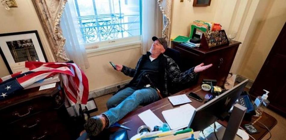 Richard Barnett en el capitolio el 6 de enero de 2021, con sus pies sobre la mesa de la oficina de Nancy Pelosi. EFE