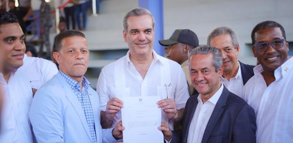 El presidente Luis Abinader entrega los fondos a José Deschamps y Oscar Galán, del Atlético Vega Real.