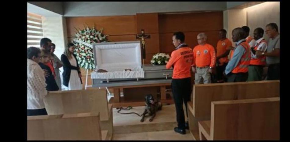 El perro Bruno hace guardia ante el féretro con los restos de Ravio, durante su velatorio.  Externa /