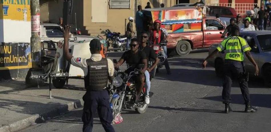 La policía nacional controla la seguridad en una calle de Port-au-Prince, Haití, el sábado 21 de enero de 2023. Una de las pandillas de Haití irrumpió en una parte clave de la capital, Port-au-Prince, y luchó con la policía durante todo el día. dejando al menos tres oficiales muertos y otro desaparecido. (Foto AP/Odelyn Joseph)