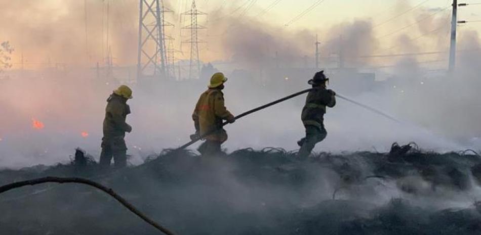 Bomberos tratan de sofocar el incendio que afectó un almacén de neumátiocos en El Almirante. Víctor Ramírez/LD