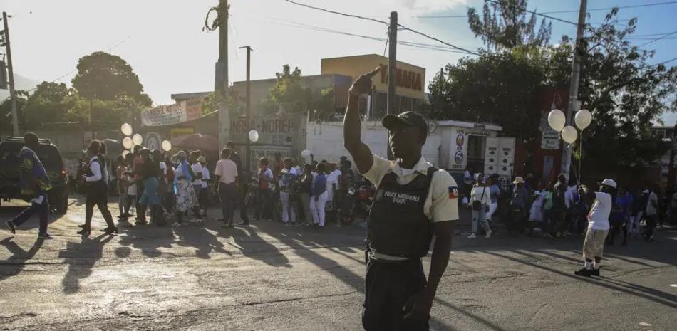 Un miembro de la policía nacional controla la seguridad en una calle de Puerto Príncipe, Haití, el sábado 21 de enero de 2023. Una de las pandillas de Haití irrumpió en una parte clave de la capital, Puerto Príncipe, y luchó con la policía. durante todo el día, dejando al menos tres oficiales muertos y otro desaparecido. (Foto AP/Odelyn Joseph)