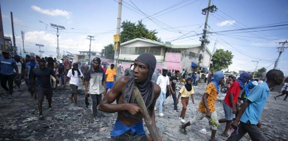 Un manifestante lleva un trozo de madera que simula un arma durante una protesta exigiendo la renuncia del primer ministro Ariel Henry, en el área de Petion-Ville de Port-au-Prince, Haití, el 3 de octubre de 2022. (AP Photo/Odelyn Joseph, Archivo)