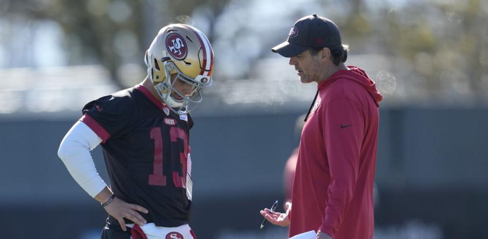 Brock Purdy, quarterback de los 49ers de San Francisco, habla con el entrenador de mariscales de campo Brian Griese.