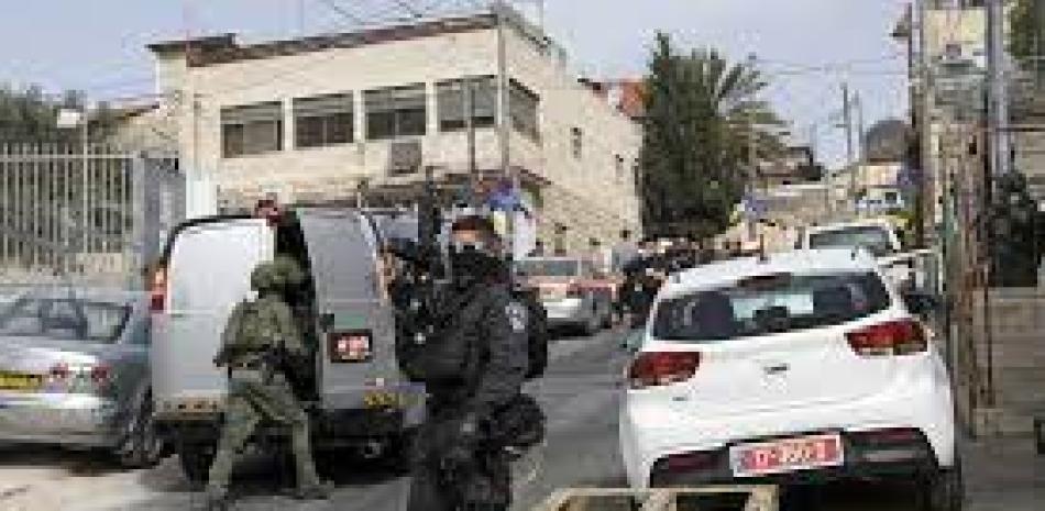 Un agente israeli custodia el lugar donde se produjo una balacera en el este de Jerusalén, el 28 de enero de 2023. Fuente: AP.