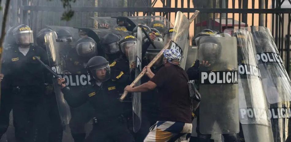 Un manifestante antigubernamental y policías antidisturbios se enfrentan durante una movilización en Lima, Perú, el jueves 19 de enero de 2023. AP