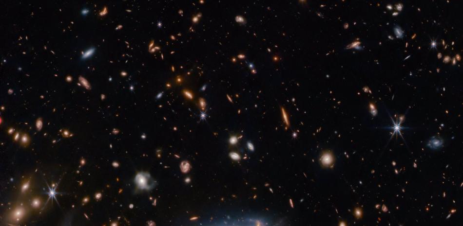 Muchas estrellas y galaxias descansan sobre un fondo oscuro, de colores variados, pero sobre todo de tonos anaranjados.

Foto: ESA/WEBB, NASA & CSA, A. MARTEL
