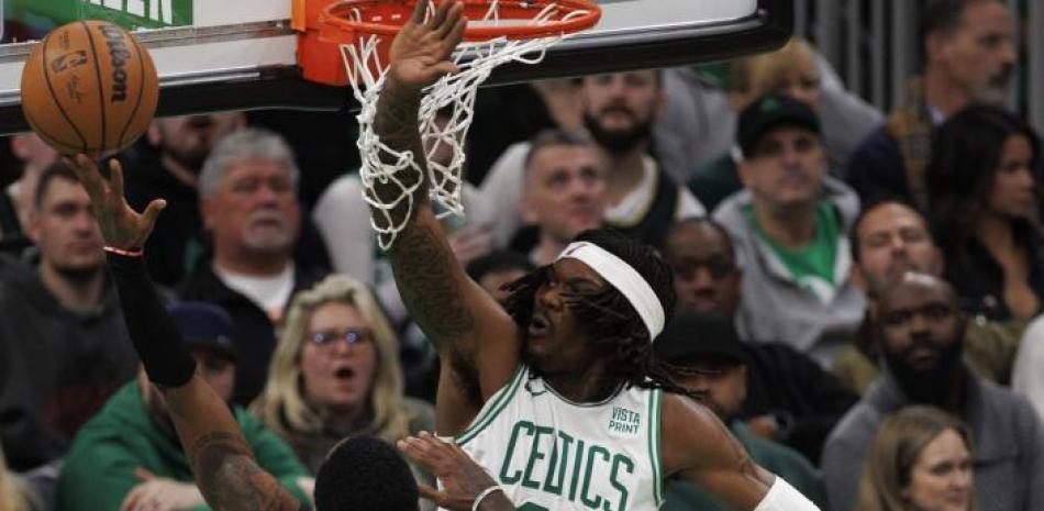 Robert Williams III, de los Celtics, defiende un intento al canasto de Kyrie Irving, de los Nets, en acción del miércoles por la noche en el baloncesto de la NBA.