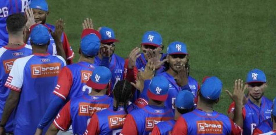 Integrantes del equipo de Puerto Rico festejan luego de su triunfo sobre Venezuela el viernes por la noche.