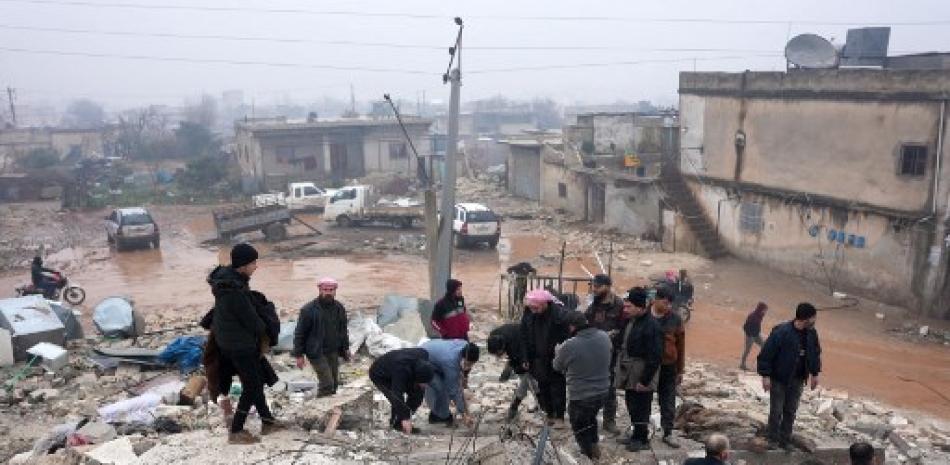 Los residentes examinan los escombros de un edificio derrumbado, en busca de víctimas y sobrevivientes, luego de un terremoto en la ciudad de Jandaris, en el campo de la ciudad de Afrin, en el noroeste de Siria, en la parte rebelde de la provincia de Alepo, el 6 de febrero de 2023.