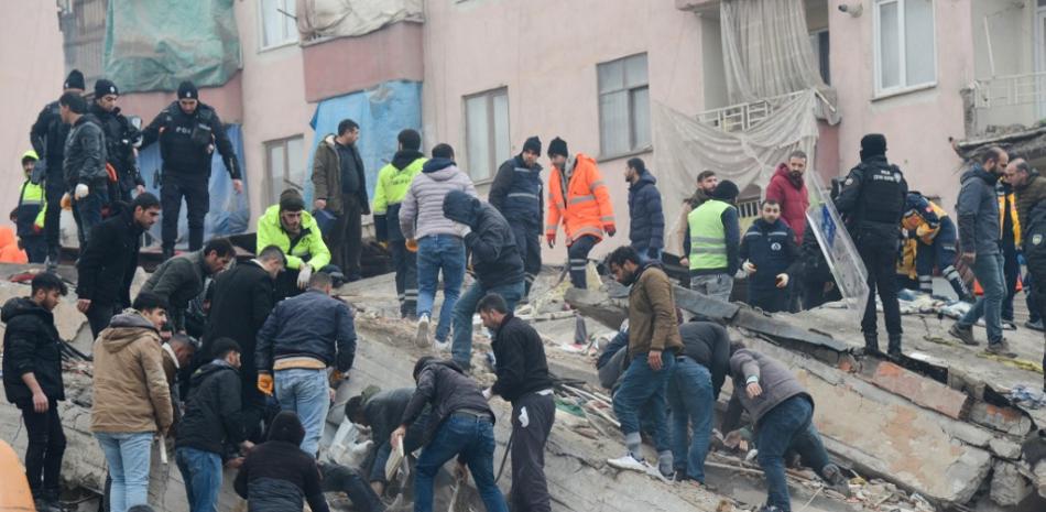 Varias personas buscan supervivientes entre los escombros en Diyarbakir, el 6 de febrero de 2023, tras el terremoto de magnitud 7,8 que sacudió el sureste del país. Fuente: AFP.