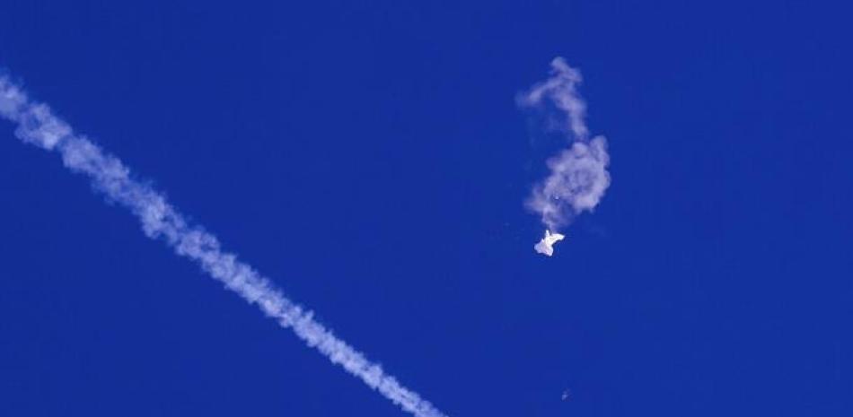 En esta foto proporcionada por Chad Fish, los restos de un gran globo flotan sobre el Océano Atlántico, frente a la costa de Carolina del Sur, con un avión de combate y su estela debajo, el 4 de febrero de 2023. AP