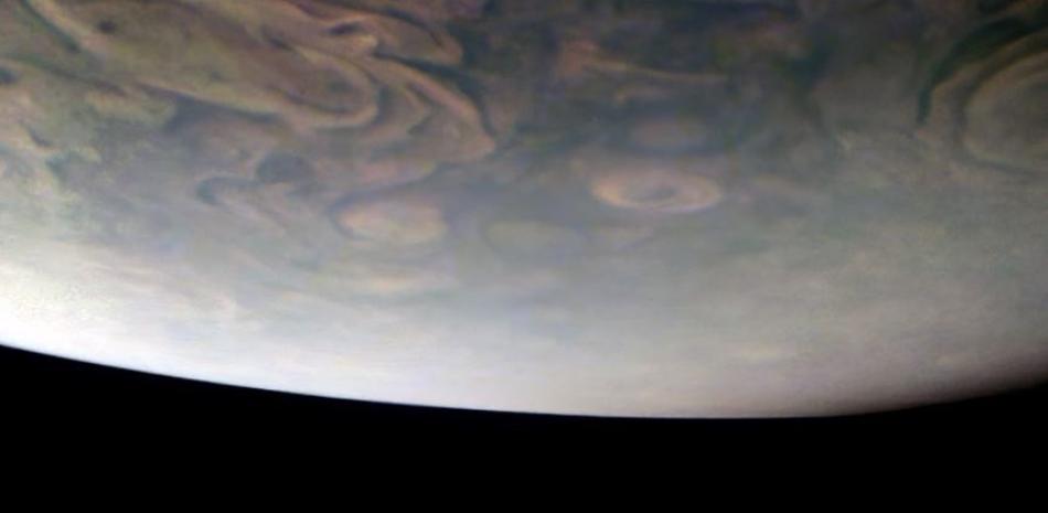 Júpiter aparece sobre dos de sus mayores lunas, captadas en la lejanía.  NASA - Archivo