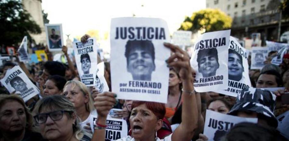 Argentinos sostienen carteles del difunto Fernando Báez Sosa con el mensaje: “Justicia por Fernando, asesinado en Gesell” durante una protesta frente al Congreso un mes después de la muerte del joven de 18 años en Buenos Aires, Argentina, el 18 de febrero. 2020.  ap